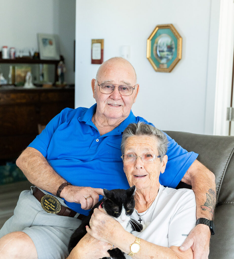 resident couple sitting on sofa with cat