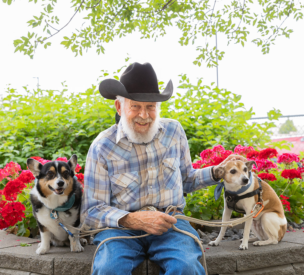 resident sitting outside with his dogs