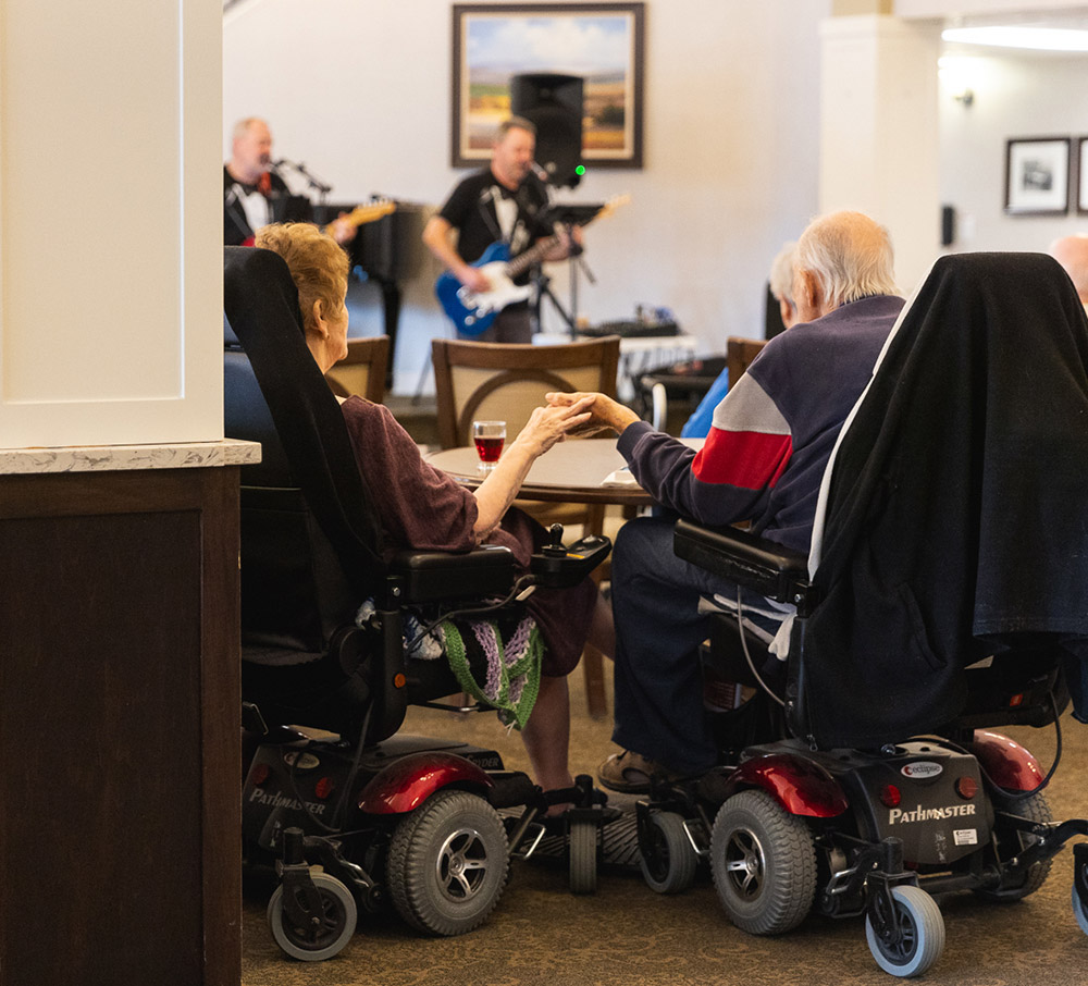 residents holding hands listening to band