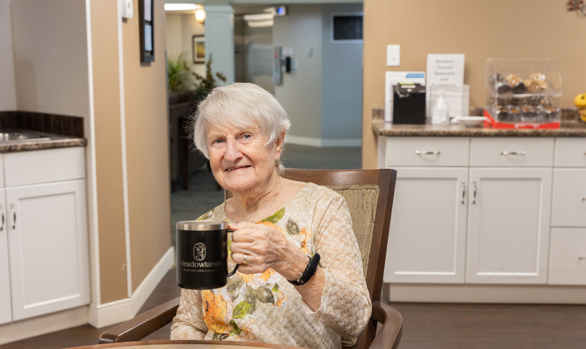 smiling resident holding mug