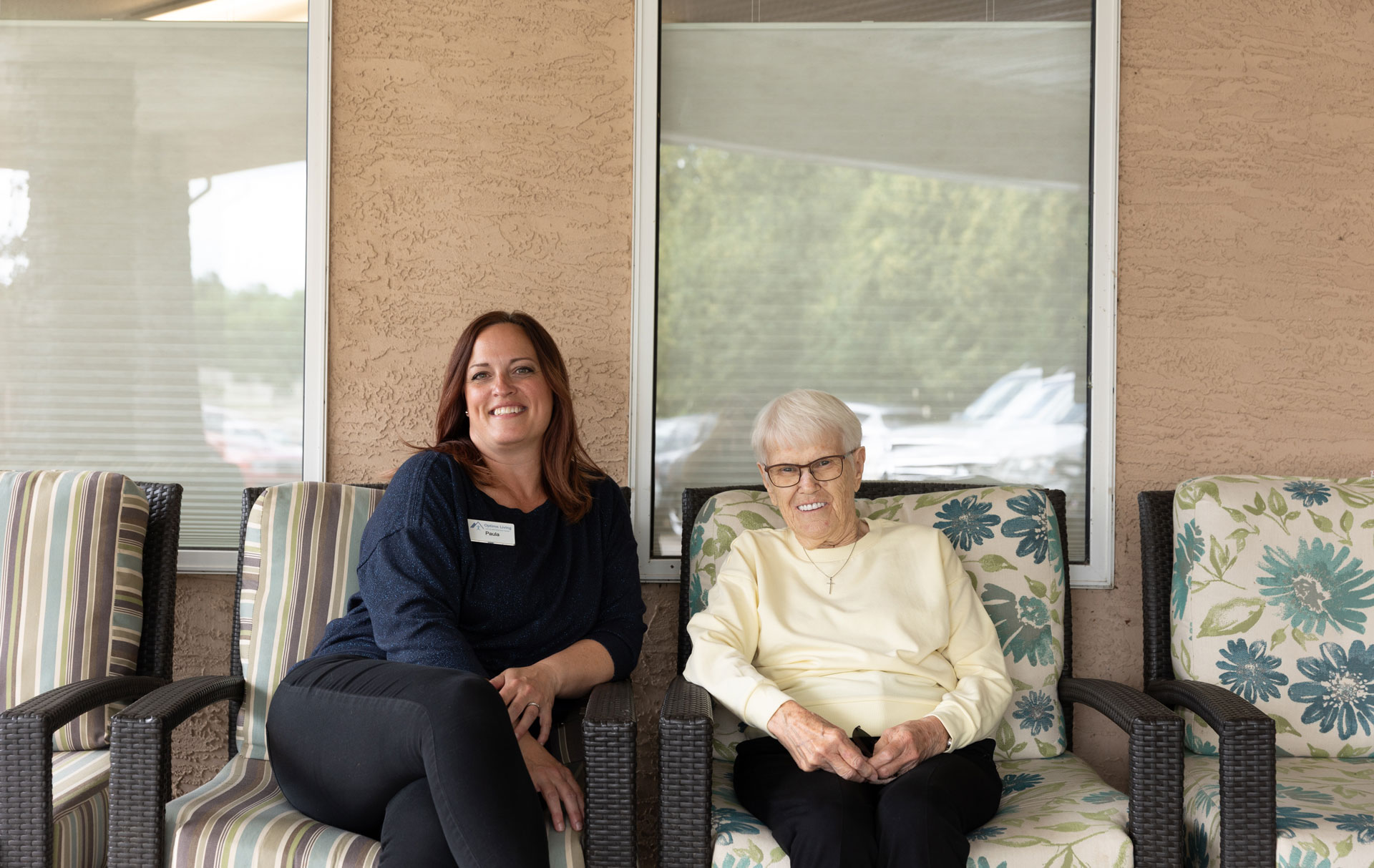 smiling team member and resident sitting outside
