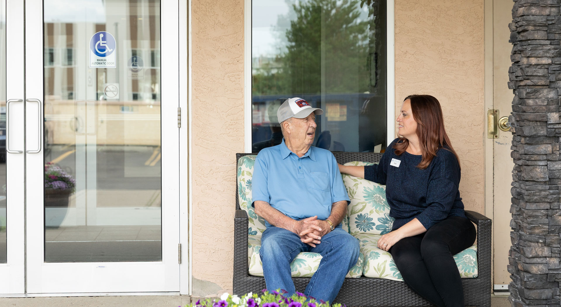team member and resident sitting outside